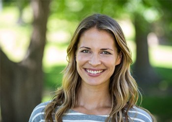 Woman with striped shirt standing outside and smiling